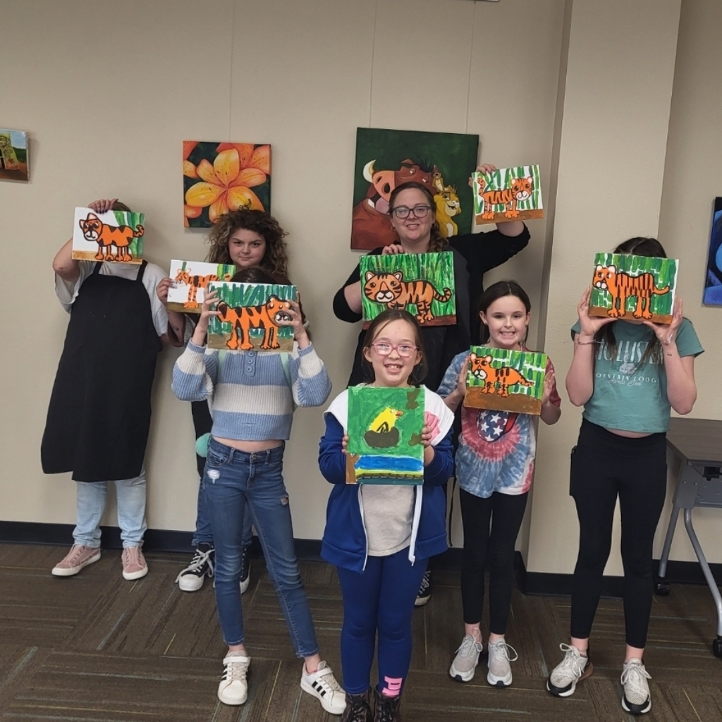 group showing off tiger paintings